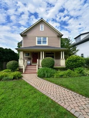 Front yard with paver walkway, manicured shrubs, ornamental grasses, and healthy lawn